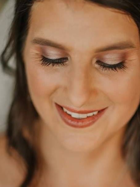 Close-up of bridal makeup with soft shimmer eyeshadow, lashes and a warm lip under a veil
