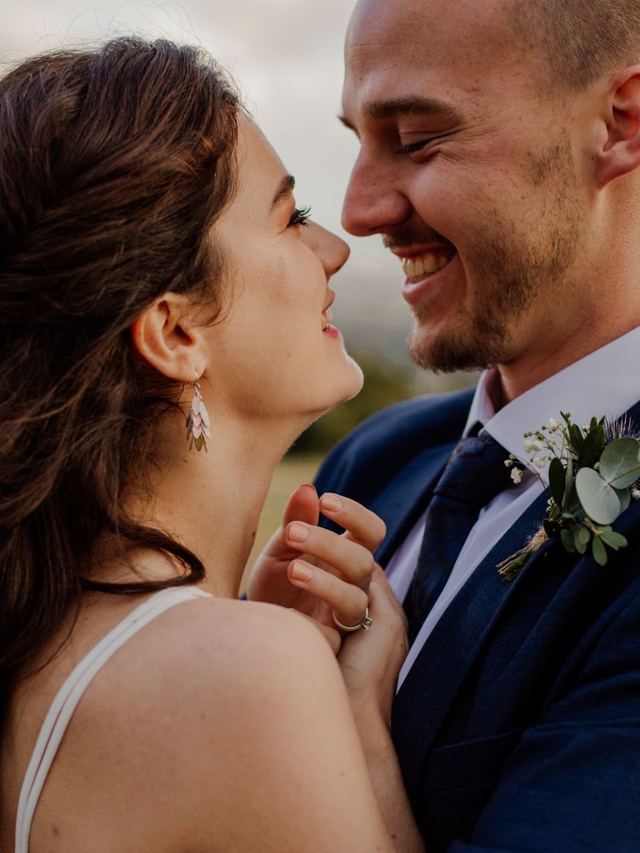 Bride and groom laughing together, bride with a soft half-up wave and natural makeup